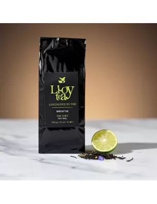 Thé vert Earl Grey bio à la bergamote Séréni'thé en sachet noir, avec citron vert et fleurs sur marbre.