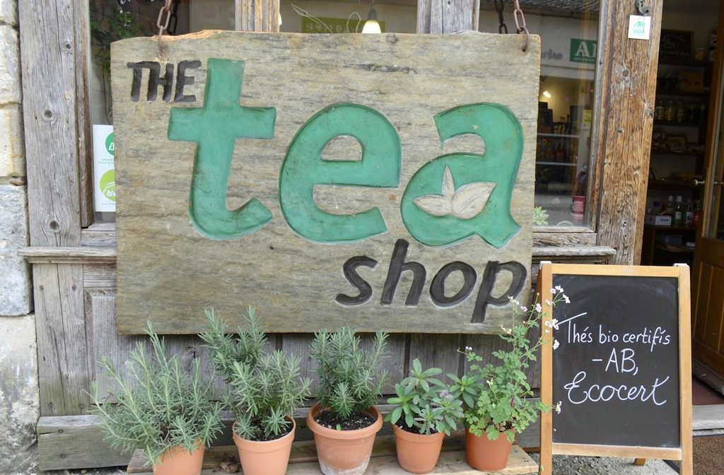 Enseigne en bois d'une boutique de thé bio français avec labels de certification affichés
